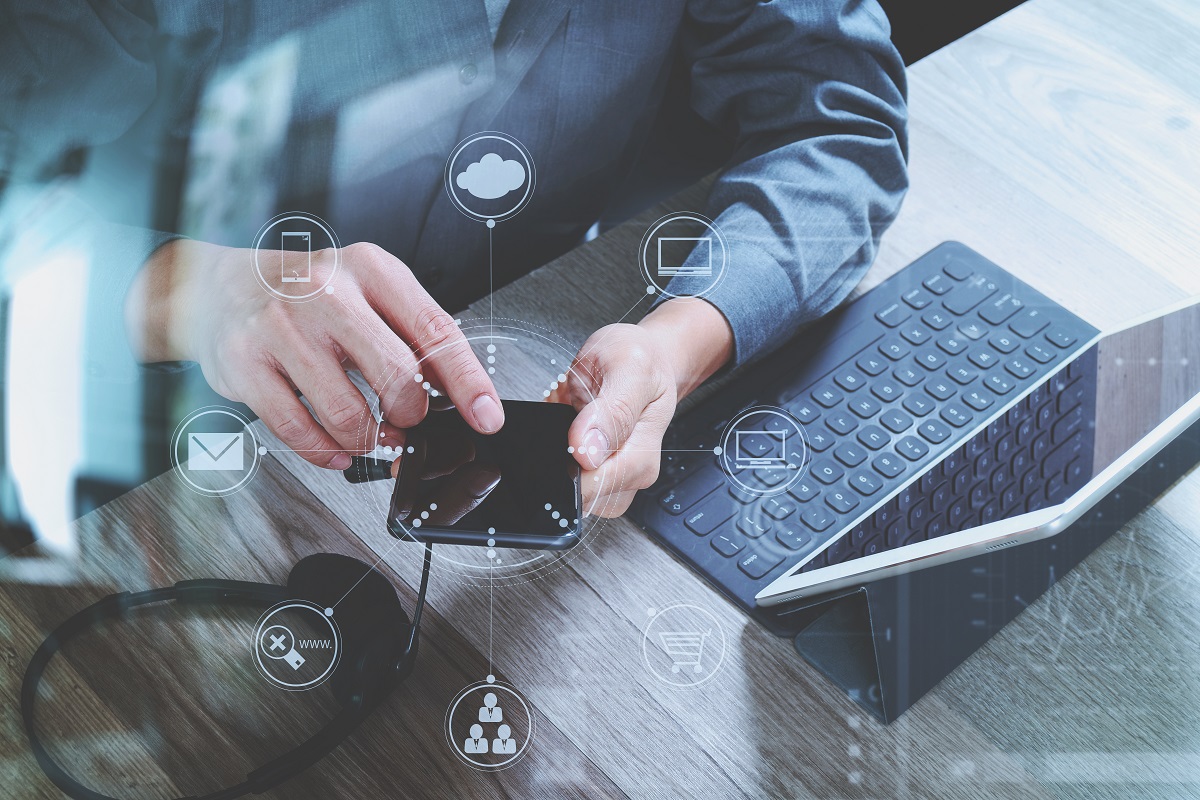 man using a phone and laptop