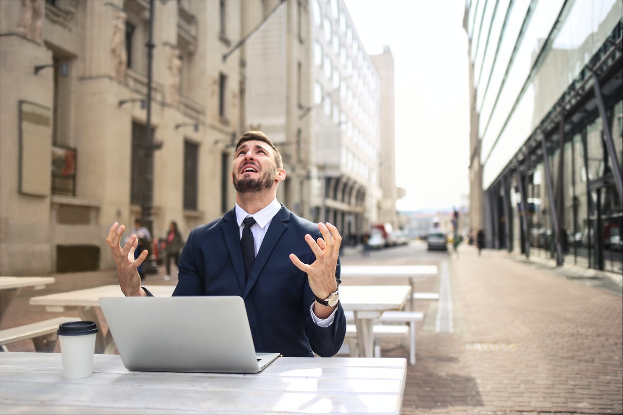 man working on a laptop angrily