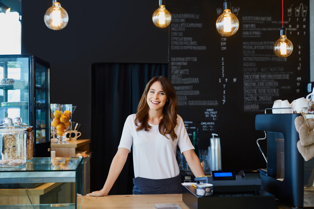 business owner standing on the cash register of her cafe