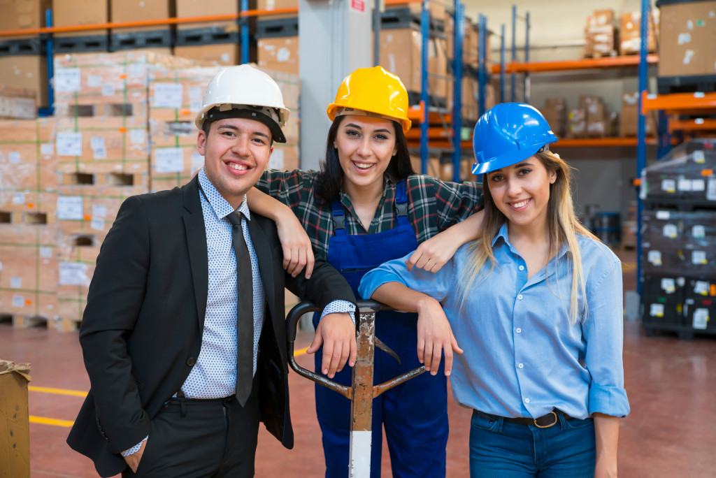 Three employees happy with their job in the warehouse