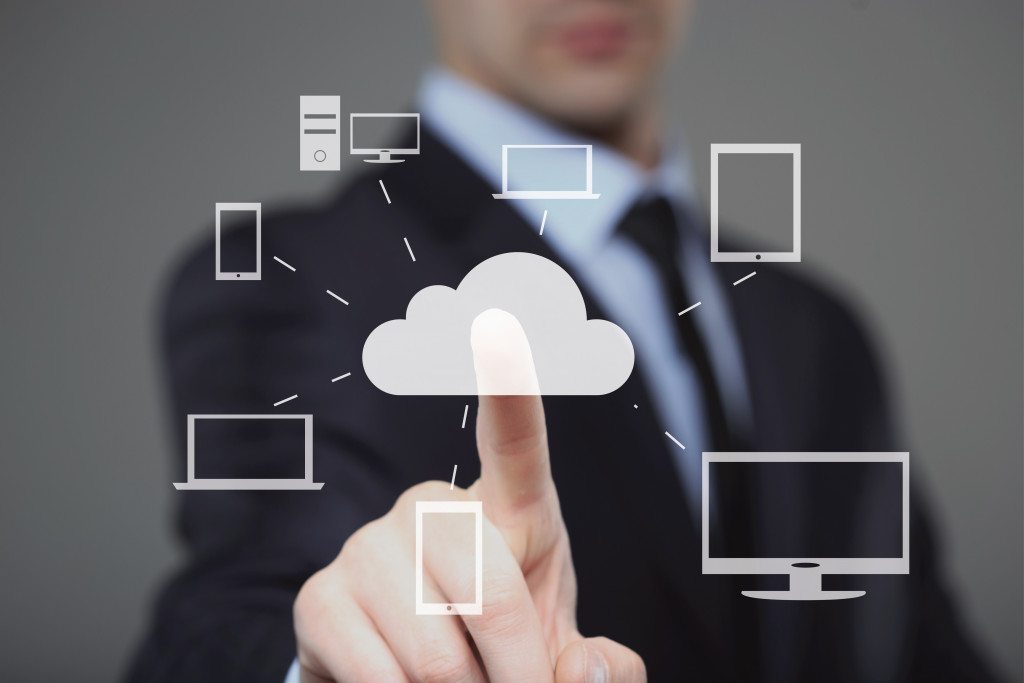 Person clicking on a visual representation of a cloud-based system for a business.