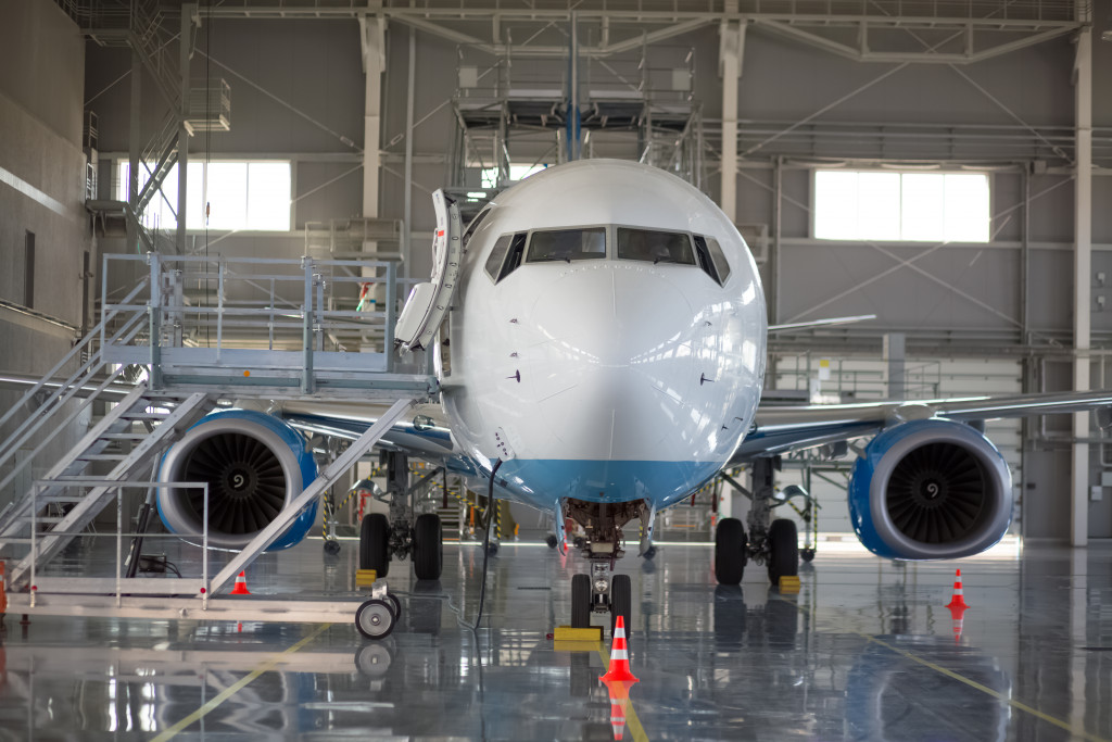 An airplane undergoing maintenance inside a hangar.