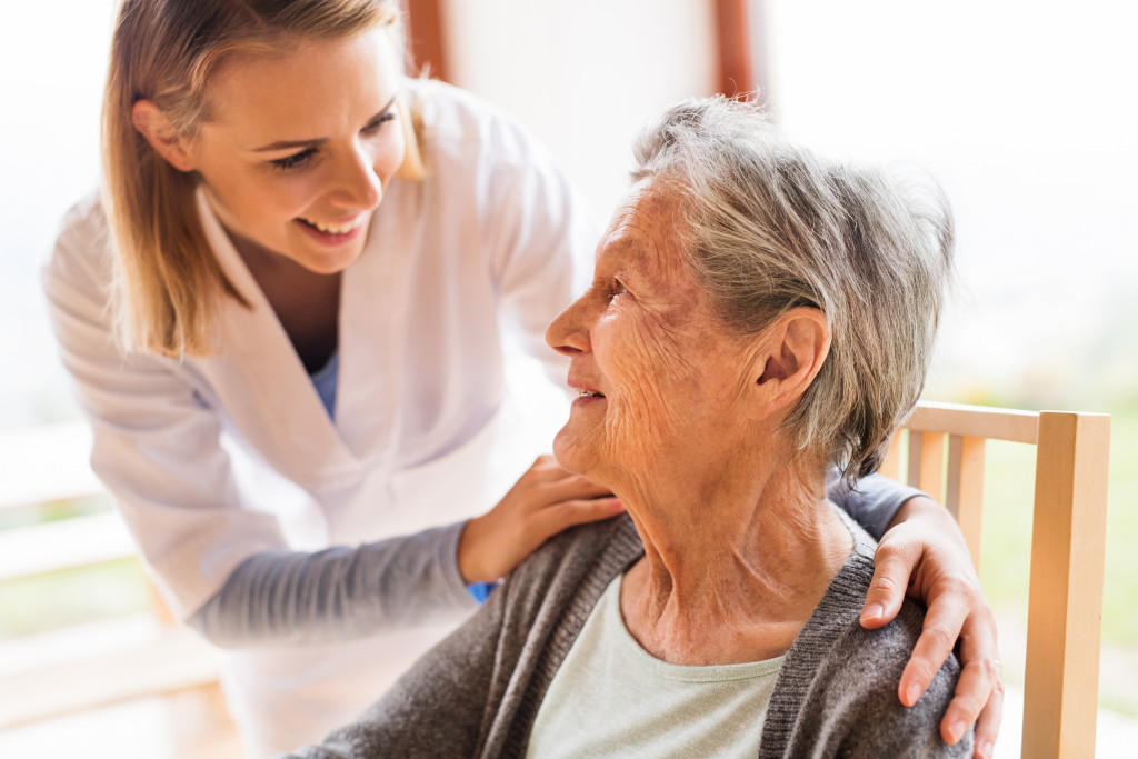 a female home health aide talks to an elderly patient