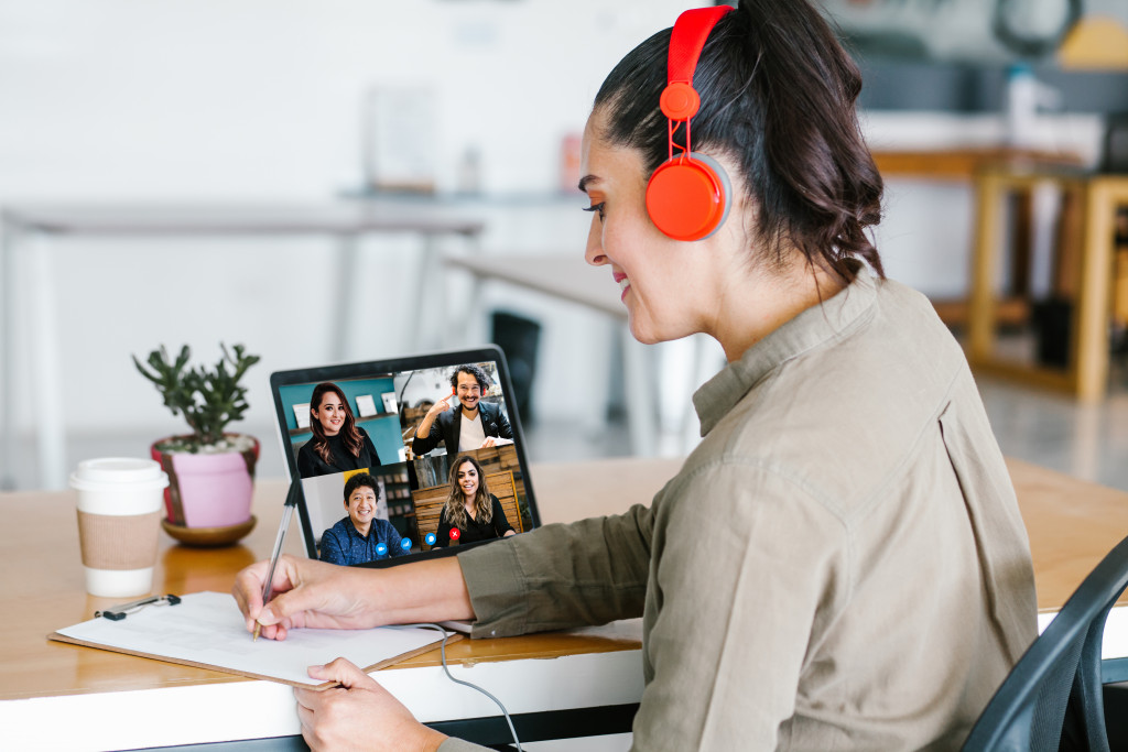 A business woman doing a video conference with her colleagues using a laptop