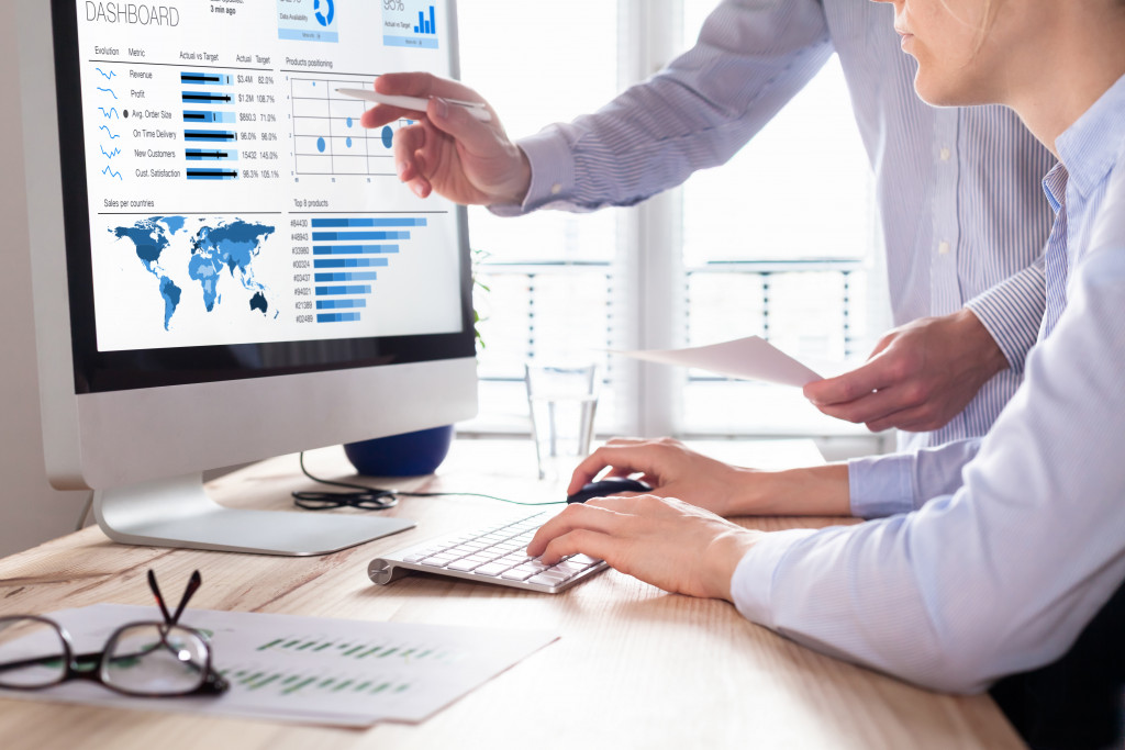 businessmen checking graphs and data on a computer