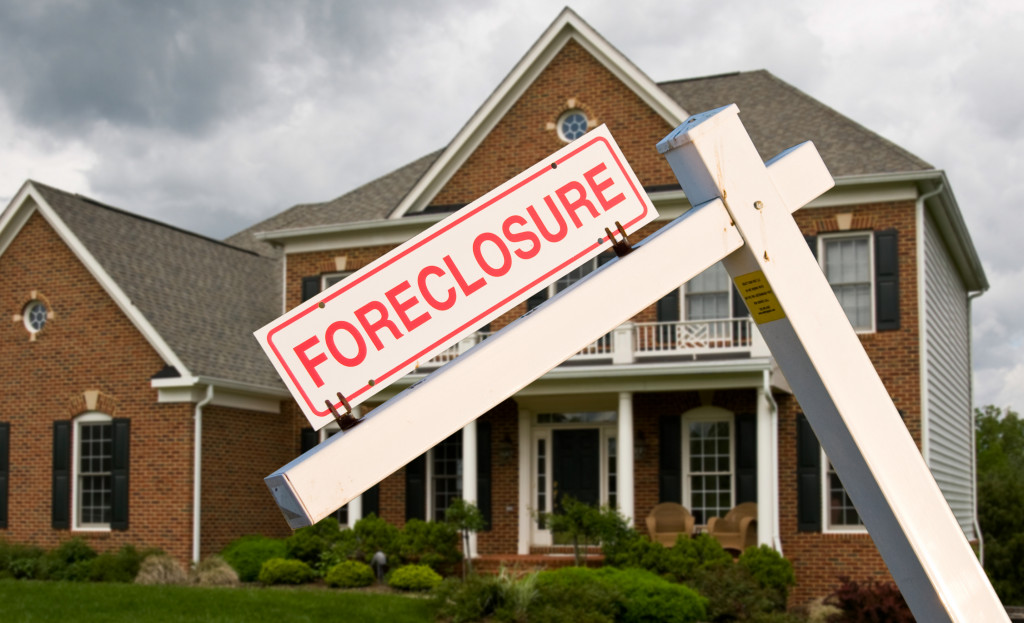 A house with a FORECLOSURE sign outside