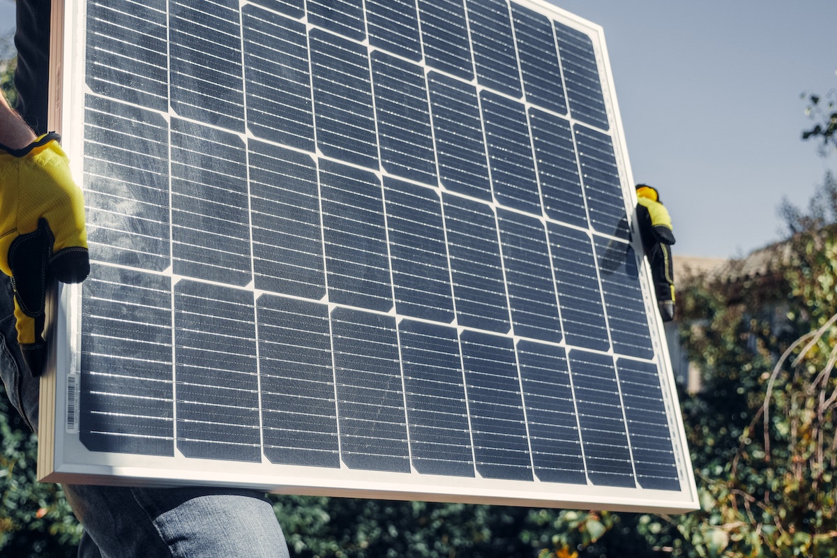 solar panel being held by a worker