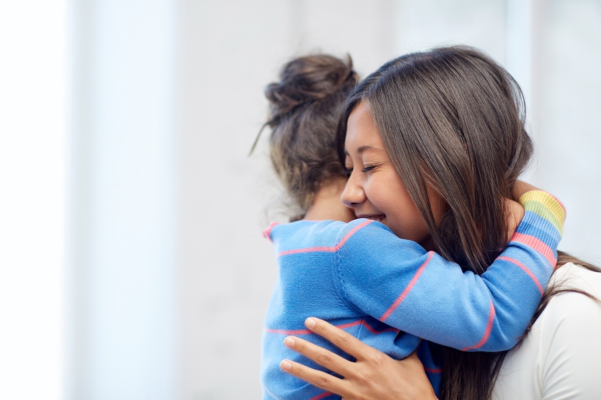 a child hugging a smiling woman 