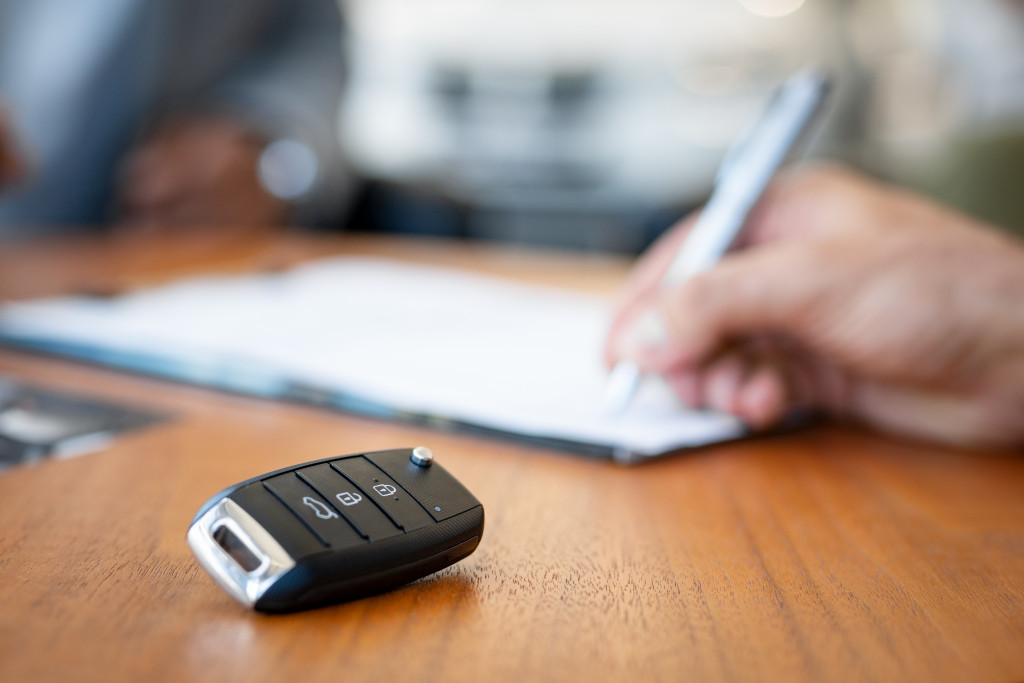 person signing documents about car insurance